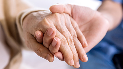 Close-up woman holding hands with her caregiver