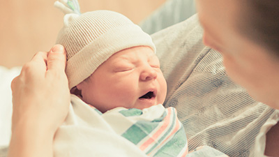 Mother holding new born baby boy in her arms