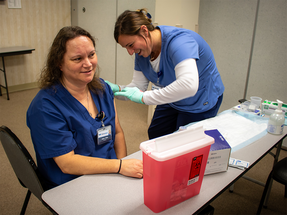 A nurse give a fellow staff member the influenza vaccine for the 2023/24 season.