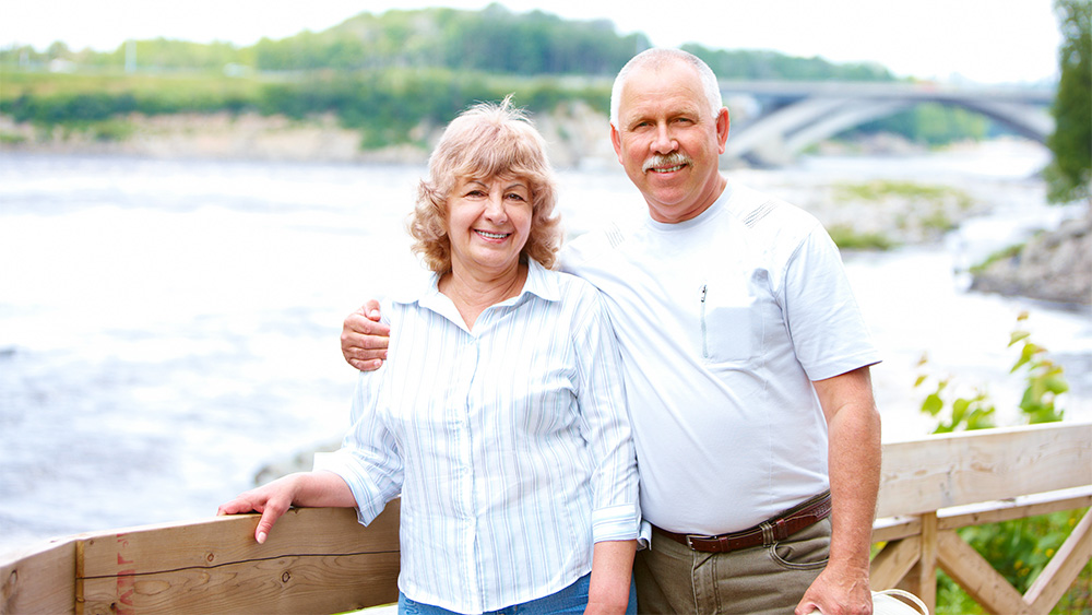 Senior Couple standing near a lake.