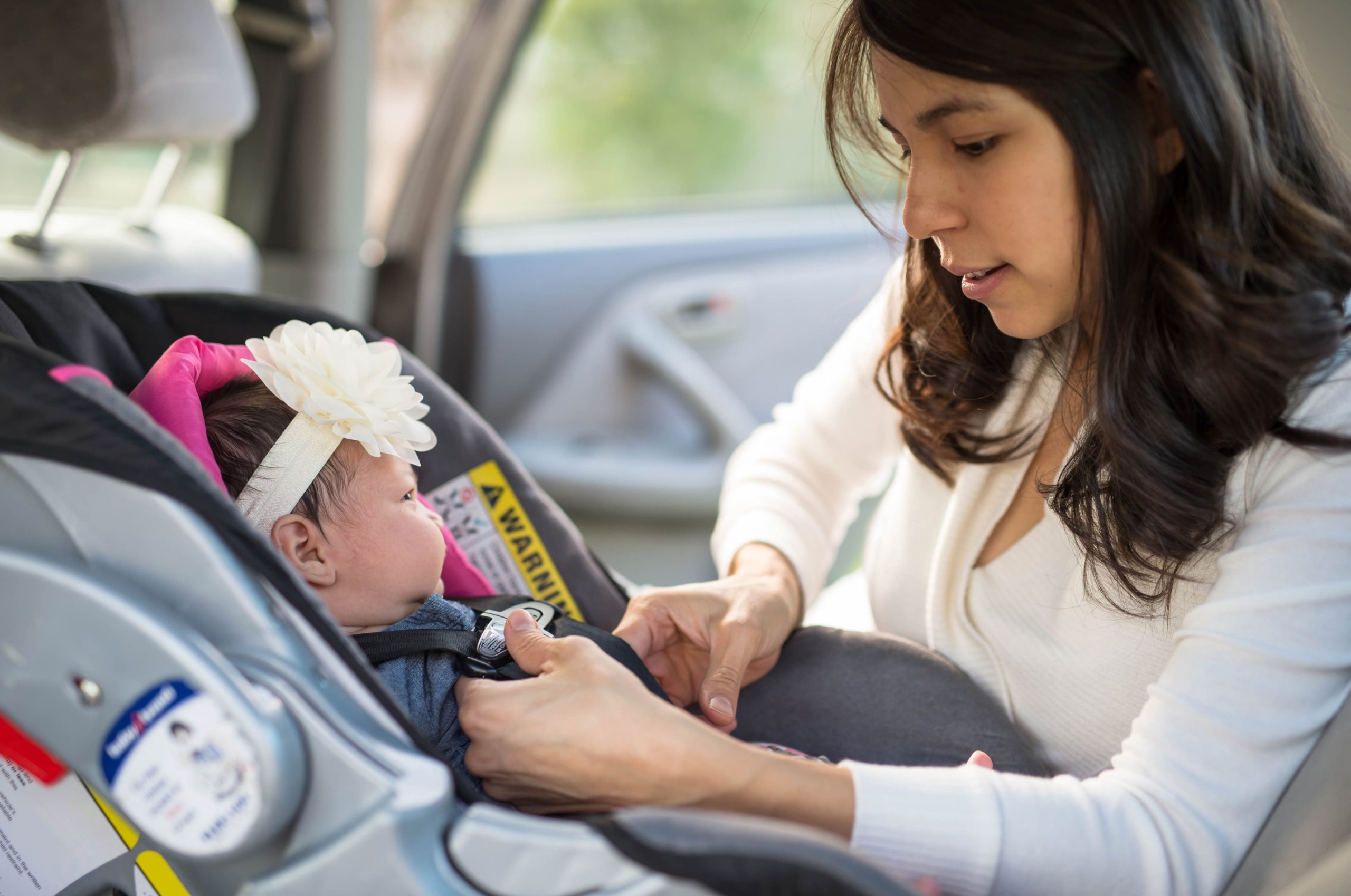 Mom placing baby in car seat Mom placing baby in car seat